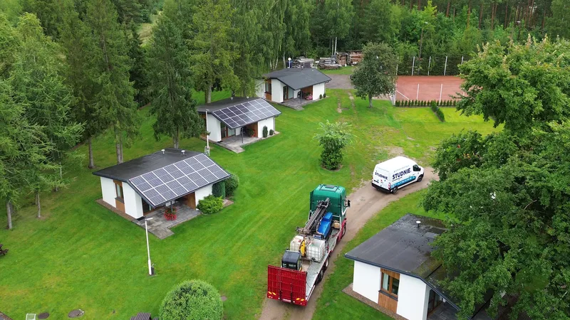 Realizacja odwiertów na osiedlu domków — wiertnica i pojazd firmowy Studnie